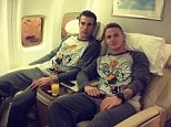Chilling with Bugs: Robin Van Persie (left) and Alexander Buttner (right) lounge in their Bugs Bunny pjs on the flight to Qatar