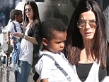 Not too heavy yet! Sandra Bullock totes her two-year-old son Louis to the barber... in lookalike white shirts and blue jeans